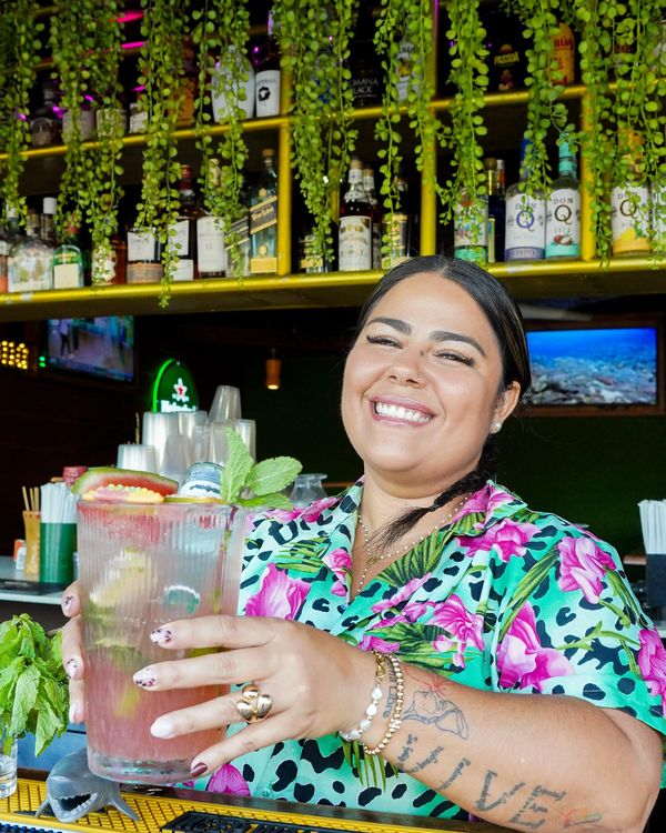 Una bartender de Café Playero sirviendo un mojito