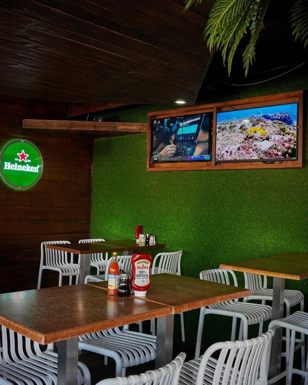 El salón con la pared verde y las pantallas